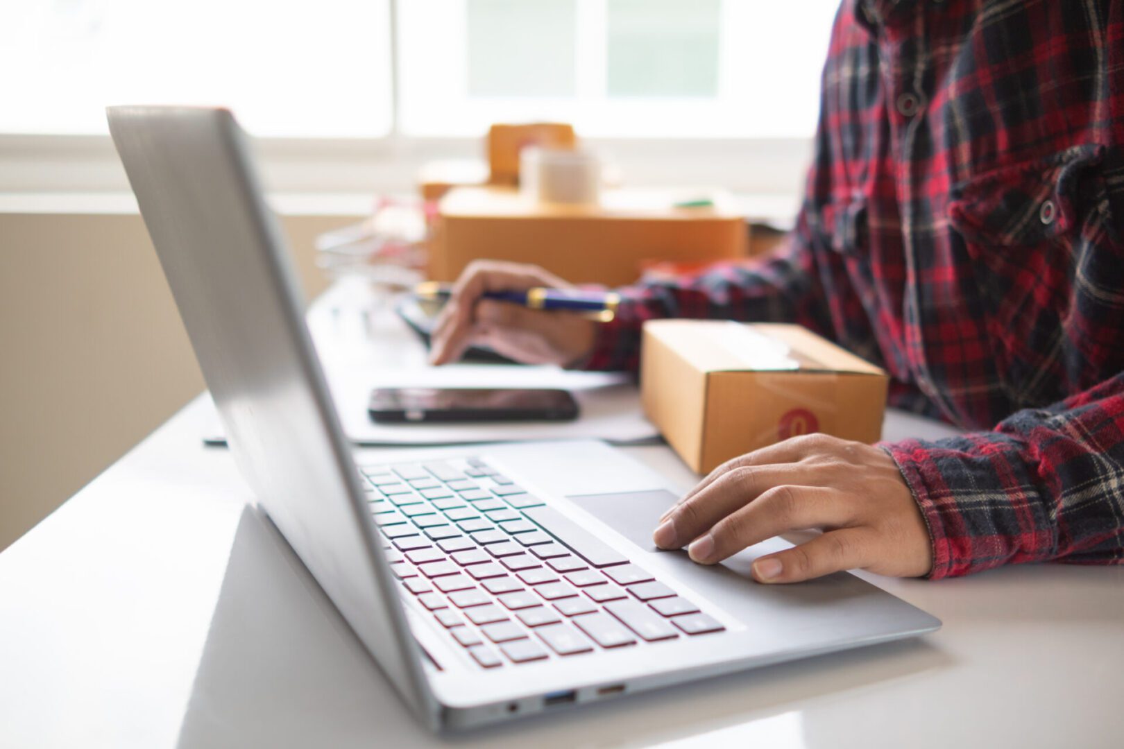 A person sitting at a laptop on top of a table.